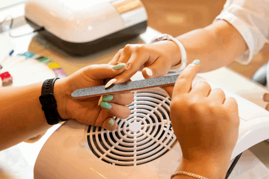 Die Nagelstudio-Inhaberin Melanie Seel feilt einer Kundin die Fingernägel.