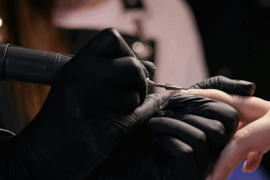 Eine Frau lässt sich von einer anderen Frau die Nägel machen.